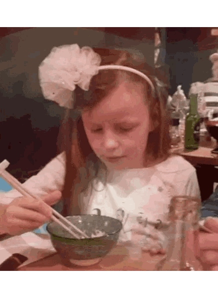 A Little Girl With A White Flower In Her Hair Is Eating From A Bowl With Chopsticks Sticker