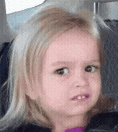 A Little Girl With Blonde Hair Is Sitting In A Car Seat Making A Funny Face . GIF