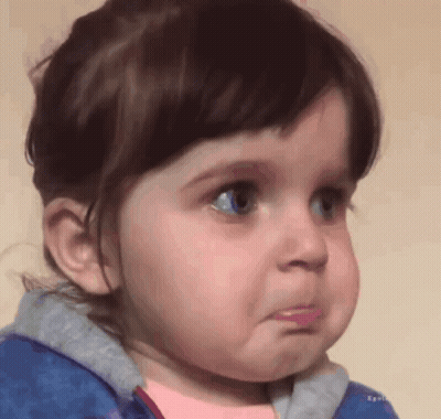 A Little Girl With Blue Eyes Is Making A Sad Face GIF