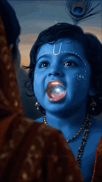 A Little Girl With Blue Paint On Her Face And A Peacock Feather In Her Hair GIF