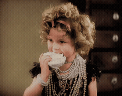 A Little Girl With Curly Hair And A Necklace With The Letter R On It GIF