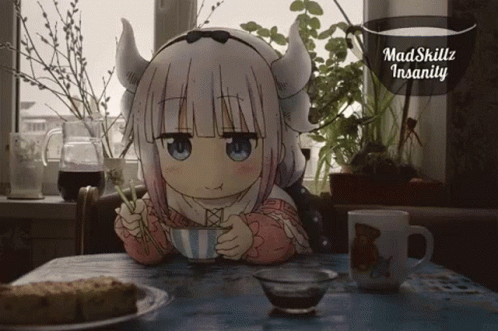 A Little Girl With Horns Is Sitting At A Table Drinking From A Cup GIF