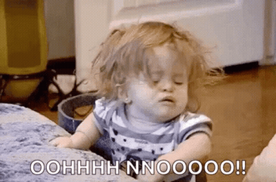 A Little Girl With Messy Hair Is Sitting On A Couch . GIF