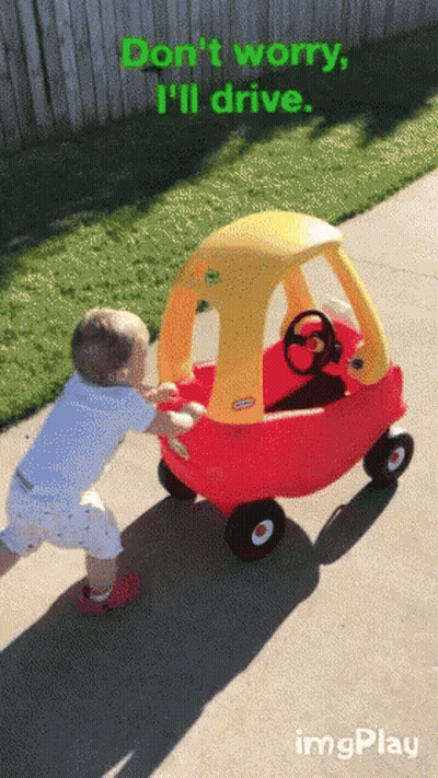 A Little Tikes Cozy Coupe Is Being Pushed By A Young Boy GIF