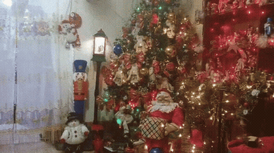 A Living Room Decorated For Christmas With A Christmas Tree And Santa Claus GIF