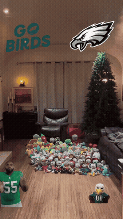A Living Room With A Christmas Tree And Stuffed Animals And The Words Go Birds On The Ceiling GIF