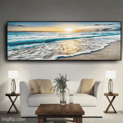 A Living Room With A Couch And A Table With A Picture Of A Beach On The Wall GIF