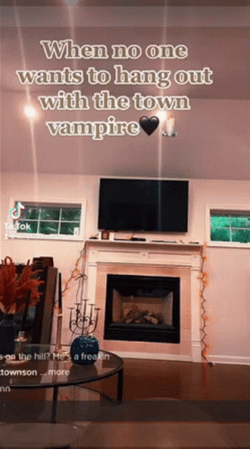 A Living Room With A Fireplace And A Tv With A Caption That Says When No One Wants To Hang Out With The Town Vampire GIF