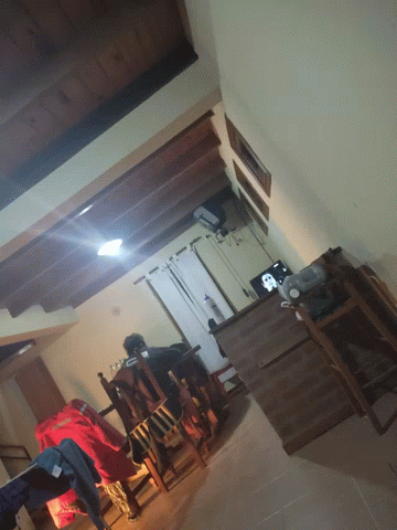 A Living Room With A Table And Chairs And A Television GIF
