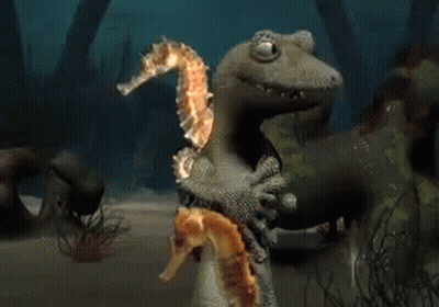 A Lizard Is Holding A Seahorse And Another Seahorse GIF
