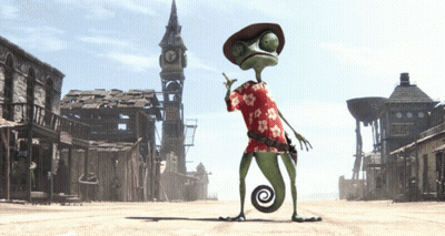 A Lizard Wearing A Hawaiian Shirt And A Cowboy Hat Stands In A Desert Town GIF
