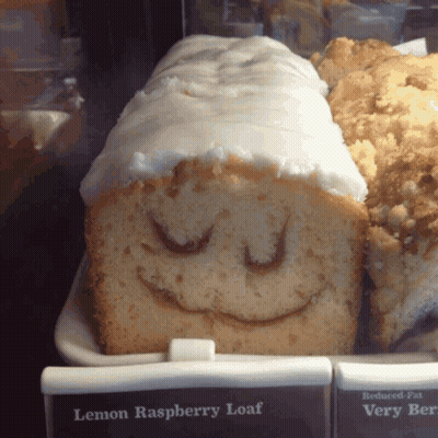 A Loaf Of Lemon Raspberry Loaf With A Smiling Face Drawn On It GIF