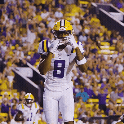 A Lsu Football Player Wearing A White Jersey With The Number 8 On It GIF