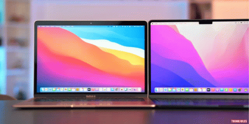 A Macbook Air Sits Next To Another Laptop On A Table GIF