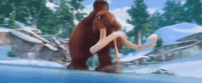 A Mammoth Is Walking Through The Snow In A Snowy Forest . GIF