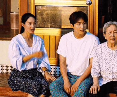 A Man , A Woman And An Older Woman Are Sitting On A Porch . GIF