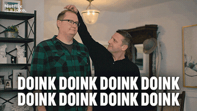A Man Adjusts Another Man 'S Head With A Caption That Says Doink Doink Doink Doink Doink Doink Doink GIF