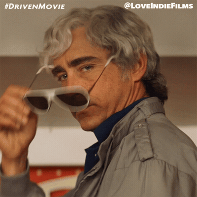 A Man Adjusts His Sunglasses With A #Drivenmovie Hashtag GIF