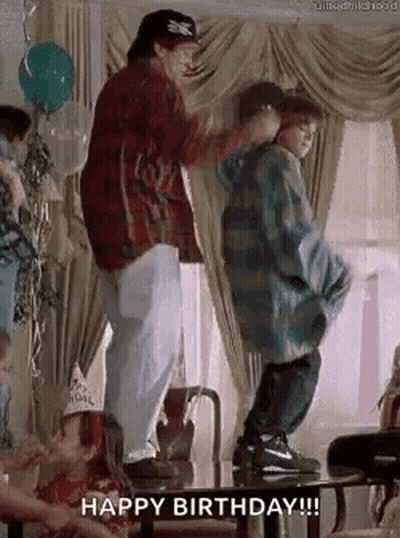 A Man And A Boy Are Dancing At A Birthday Party In A Living Room . GIF