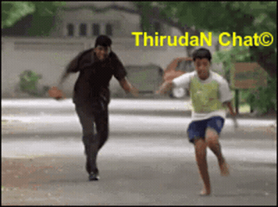 A Man And A Boy Are Running Down A Street With The Words Thirudan Chat On The Bottom Right GIF