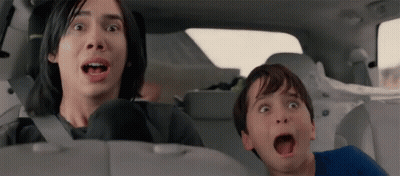 A Man And A Boy Are Sitting In The Back Seat Of A Car Making Funny Faces . GIF