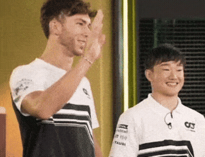 A Man And A Boy Are Standing Next To Each Other And One Of Them Is Waving . GIF