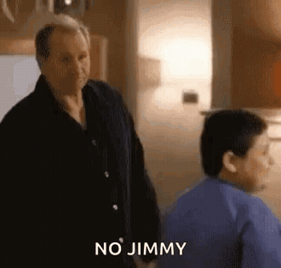 A Man And A Boy Are Standing Next To Each Other In A Room And The Man Is Talking To The Boy . GIF