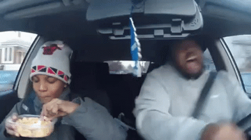 A Man And A Child Are In A Car Eating Food GIF