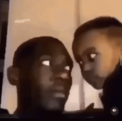 A Man And A Child Are Looking At Each Other And Making Funny Faces . GIF