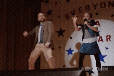 A Man And A Girl Are Dancing In Front Of A Sign That Says " Everyone " GIF
