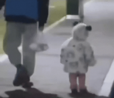A Man And A Little Girl Are Walking Down The Sidewalk . GIF