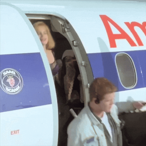 A Man And A Woman Are Boarding An Airplane That Says Saab On The Side GIF