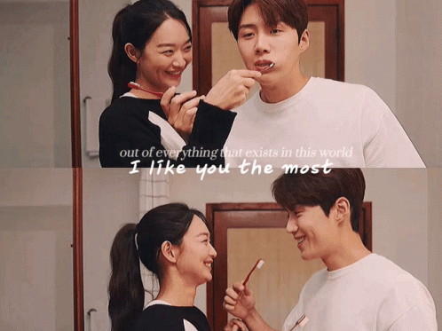 A Man And A Woman Are Brushing Their Teeth In A Bathroom GIF