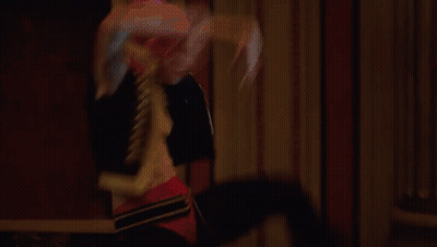 A Man And A Woman Are Dancing In A Large Hallway GIF