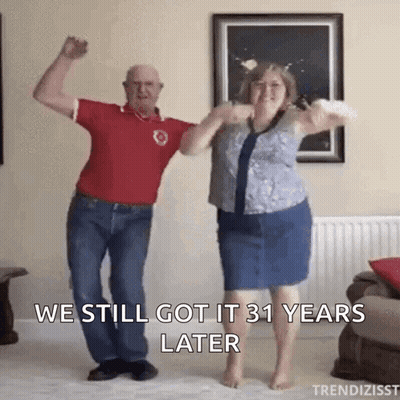 A Man And A Woman Are Dancing In A Living Room With The Caption We Still Got It 31 Years Later GIF