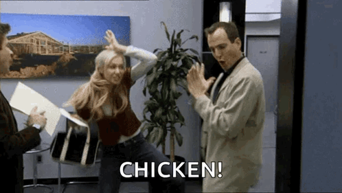 A Man And A Woman Are Dancing In An Office While A Man Says Chicken . GIF