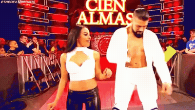 A Man And A Woman Are Dancing In Front Of A Banner That Says Cien Almas GIF