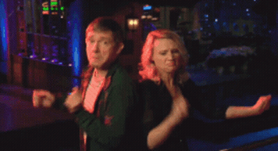 A Man And A Woman Are Dancing In Front Of A Building GIF
