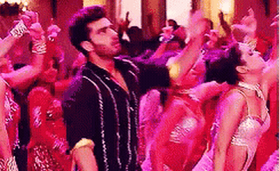 A Man And A Woman Are Dancing In Front Of A Crowd Of People . GIF