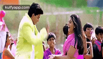 A Man And A Woman Are Dancing In Front Of A Crowd . GIF