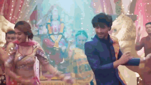 A Man And A Woman Are Dancing In Front Of A Lion Statue GIF