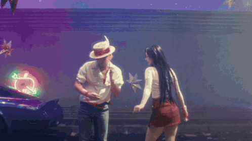 A Man And A Woman Are Dancing In Front Of A Neon Sign That Says ' Coca Cola ' GIF