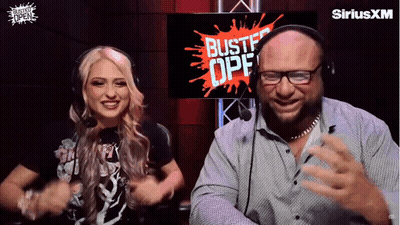 A Man And A Woman Are Dancing In Front Of A Screen That Says Bustf Opf GIF