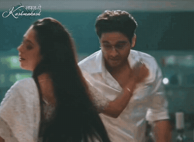 A Man And A Woman Are Dancing In Front Of A Sign That Says Kashmakash GIF