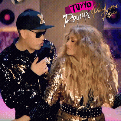 A Man And A Woman Are Dancing In Front Of A Sign That Says " Tuyyo " On It GIF