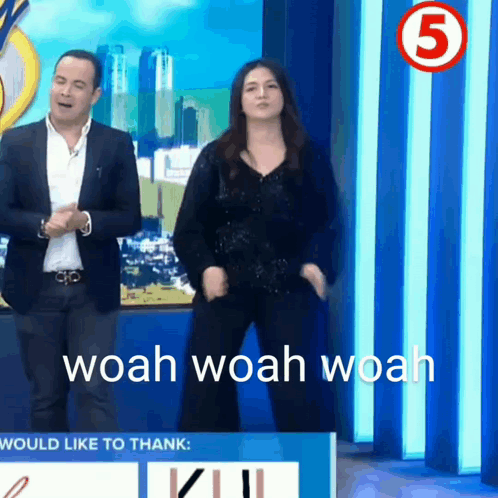 A Man And A Woman Are Dancing In Front Of A Sign That Says Would Like To Thank GIF