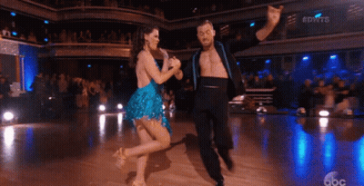 A Man And A Woman Are Dancing On A Dance Floor GIF