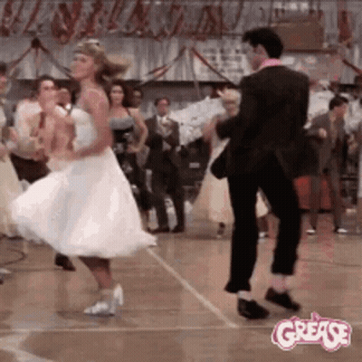 A Man And A Woman Are Dancing On A Dance Floor In A Room . GIF