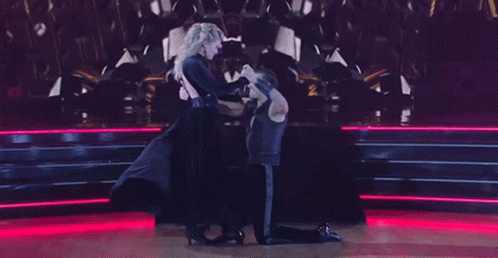 A Man And A Woman Are Dancing On A Dance Floor GIF