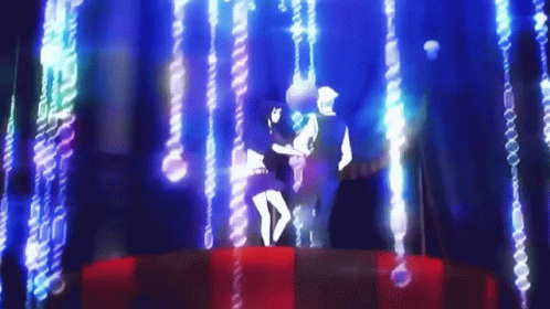 A Man And A Woman Are Dancing On A Stage In Front Of A Blue Background . GIF